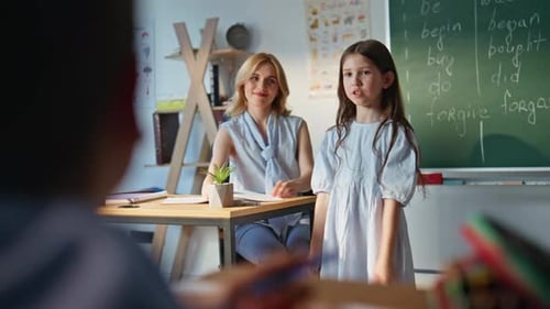 Little Girl Counting Blackboard at Elementary School Lesson Woman Teacher