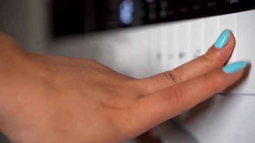 Young woman setting the washing machine 4K