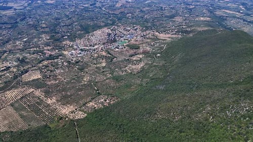 Camera panning over small town nestled in lush green valley