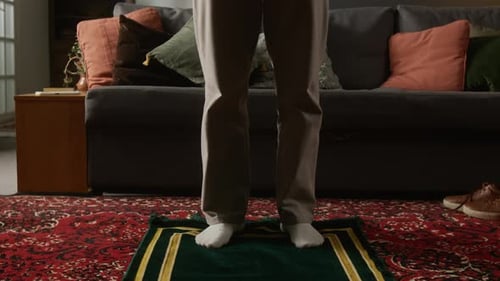 Man Standing on Prayer Rug in Living Room