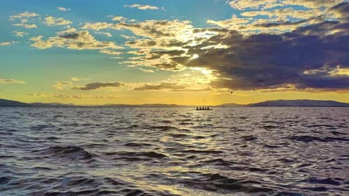Yellow Sunset Over The Ocean And Mountain Ranges On The Horizon