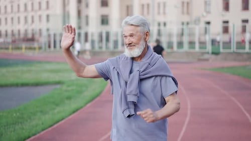 Old man run at sport stadium. Grandpa jogging arena. Elderly sportsman workout.