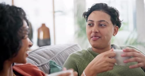 Two Women Enjoying Coffee and Conversation on Couch