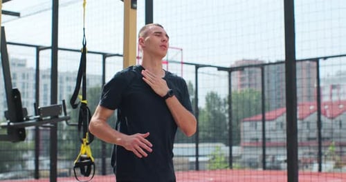 Man Stretching Arms Outdoors on Sunny Day