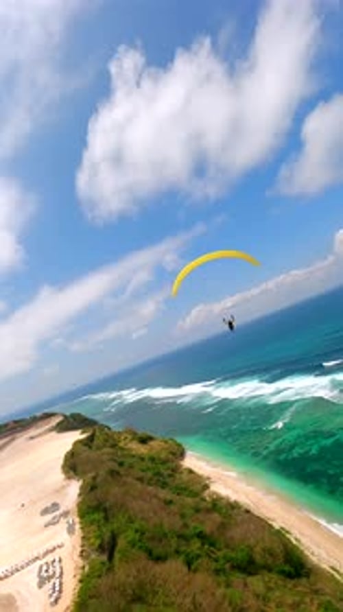 FPV Drone Shot of Paragliders Soaring Over Turquoise Waves at Pandawa Beach Bali