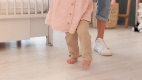 Baby Taking First Steps with Adult Guidance at Home