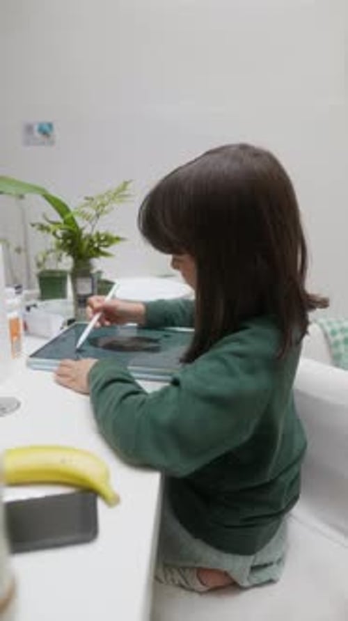 Child Drawing on Tablet with Stylus Indoors