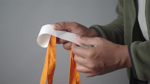 Mano de hombre que sostiene un recibo de compra y una bolsa
