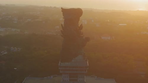 Vue aérienne de la statue de Garuda Wisnu Kencana dans la brume chaude du coucher de soleil en Indonésie