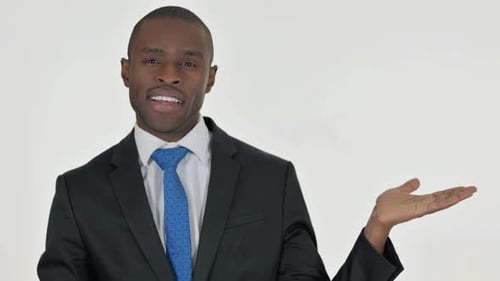 Portrait of Pointing African Businessman Showing Copyspace on White Background