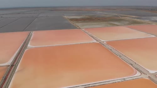 Vista aérea acima de piscinas de produção de sal vermelho na Albânia Drone Shot