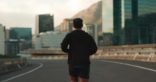 Running, fitness and back of man in city for marathon training, exercise and cardio workout