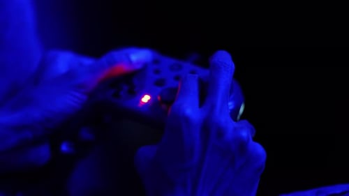 Hands Playing Video Game with Controller at Night