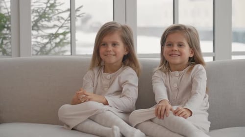 Smiling Girls Sitting Together on a Couch