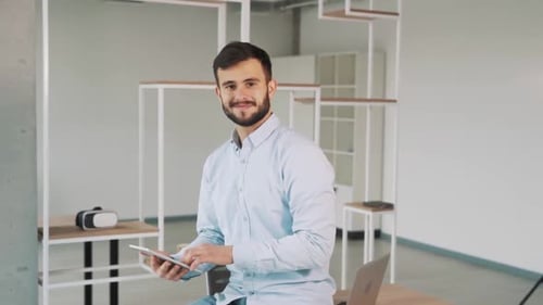 Man with Tablet Smiling in Modern Office
