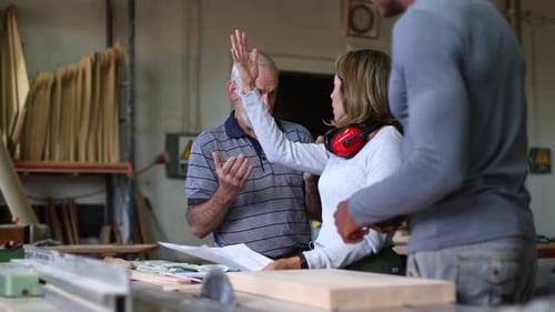 Carpentry Team Discussing Plans in Workshop, Woodworking Project