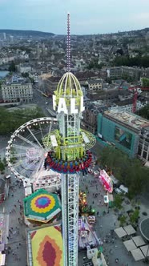 A beautiful aerial drone doll is flying towards a giant wheel of the amusement park