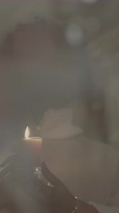 Woman Holding Candle Indoors with Eyes Closed
