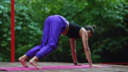 Woman Doing Yoga Outside on Wooden Deck