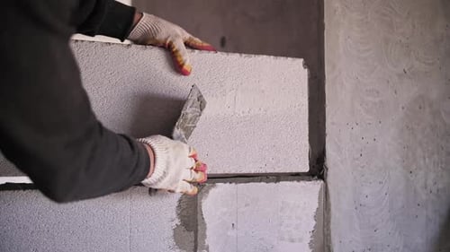 Builder Lays a Wall of Blocks