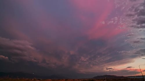 Timelapse de una colorida puesta de sol que se desvanece al borde de una tormenta