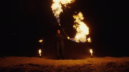 FireMaster présente un spectacle de feu spectaculaire en plein air pendant la nuit, un cascadeur avec des torches allumées dans l'obscurité