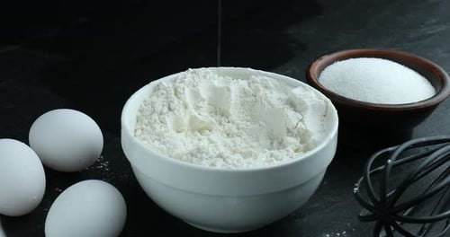 Baking ingredients: Eggs being added to flour