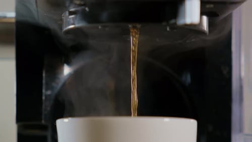 Close Up Slow Motion Shot of Black Coffee Pouring From the Machine to White Cup Fresh Cafe in the