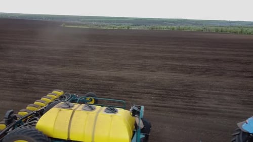 Blue tractor OA working on the field in Ukraine