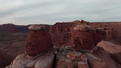Aerial: Fly through boulders to reveal Valley of the Gods Utah in morning light