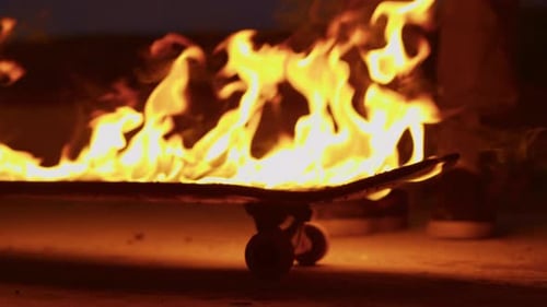 Burning Skateboard on Ground at Night