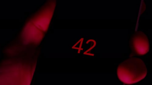 A Dark Screen with Red Number on a Smartphone, Indicating a Countdown Timer in Progress, Signaling