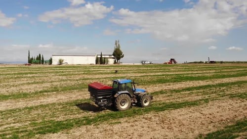 Tractor Driving Through Field on Sunny Day