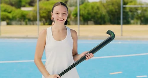 Atleta feminina segurando equipamento de hóquei procurando motivada para a competição