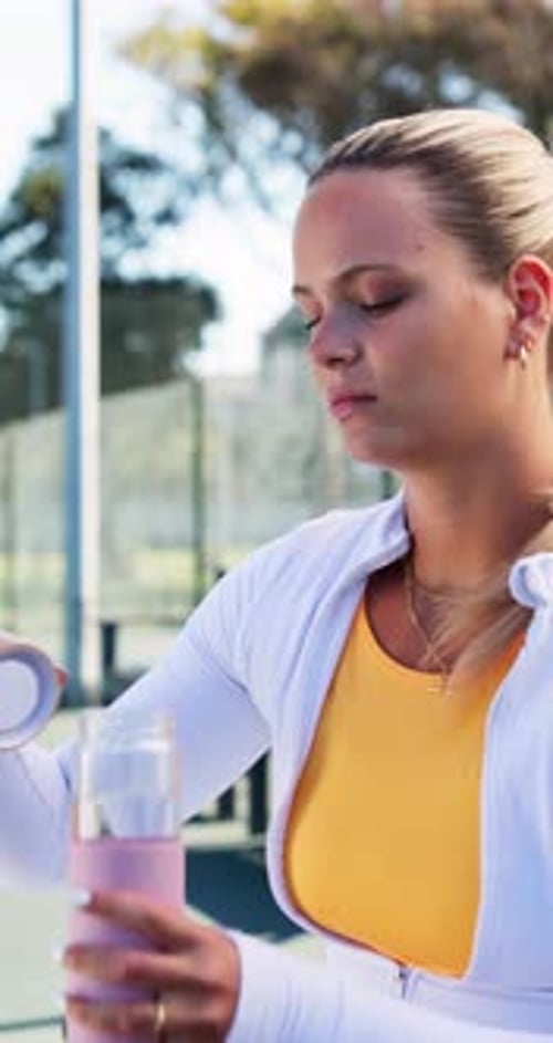 Young Woman Drinks Water After Exercise Outdoors