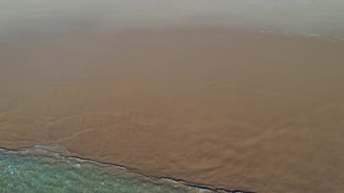 Tropical beach aerial view, Top view of waves break on tropical yellow sand beach. Sea waves seamles