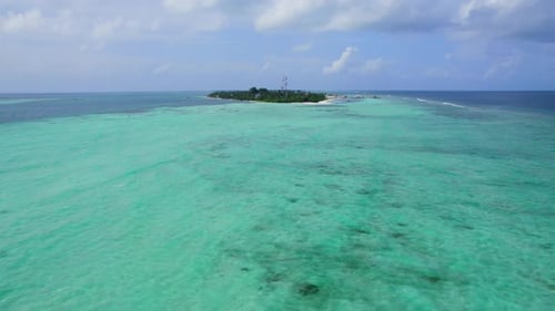 Drone flying over turquoise seawater towards Dhangeti tropical and local island, Maldives