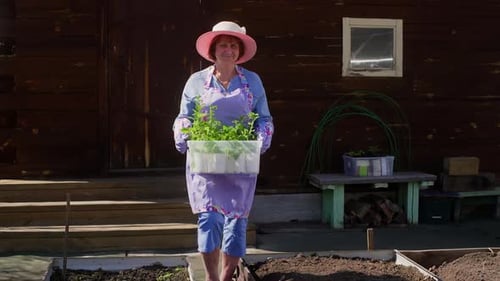 Woman with Various Plant Saplings Walking Outside House for Gardening