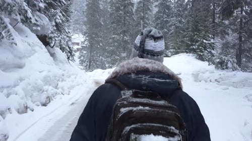 Young Guy Walks Along a Snowy Path in the Mountains