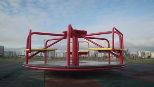 Merry-Go-Round Turning Slowly in Urban Playground