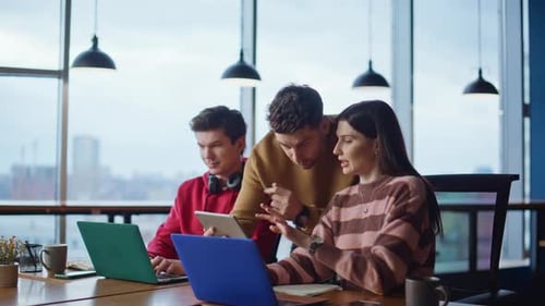 Team Collaboration in Modern Office with Laptops and Tablet