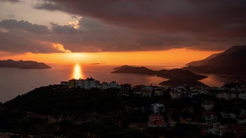 Soleil visible depuis des nuages sombres et se cachant dans la mer au-delà de l'horizon