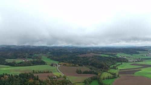 Rural Landscape With Green Fields And Forests On A Cloudy Day Of Autumn