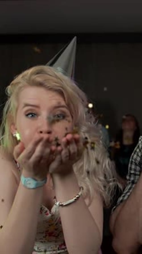 Joyful Woman Blowing Confetti at Birthday Party