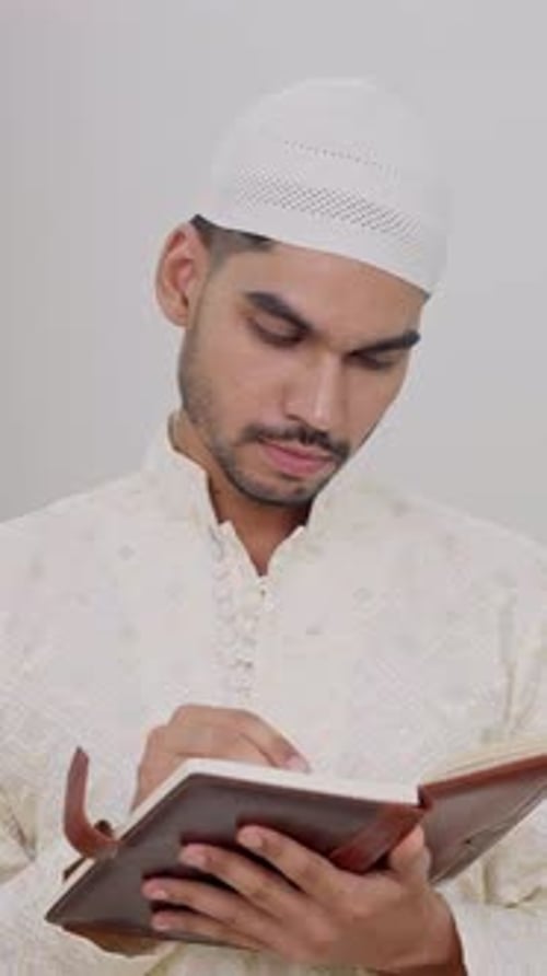 Man Writes in Notebook Indoors