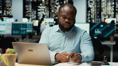 Man Working Late on Laptop in Office at Night