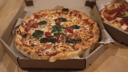 sliding shot of delicious Italian pizzas delivered in boxes on the table