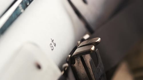 Close View of a Typewriter Showing a Paper with the Word Start Typed on It While the Machine is in