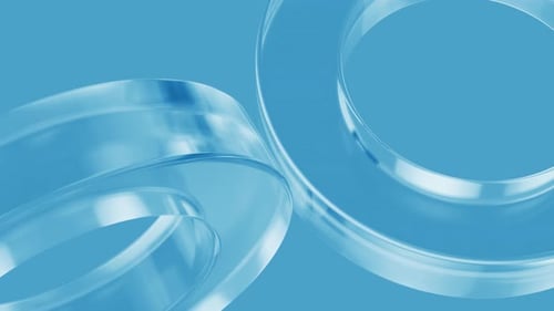 Transparent glass rings rotating on blue background