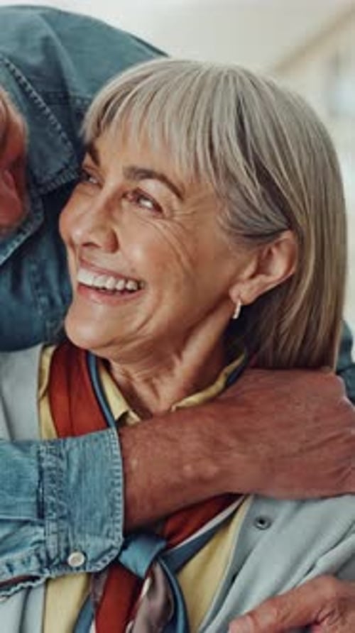 Senior couple, hug and laugh on sofa with surprise, bonding and reflection in lounge at house